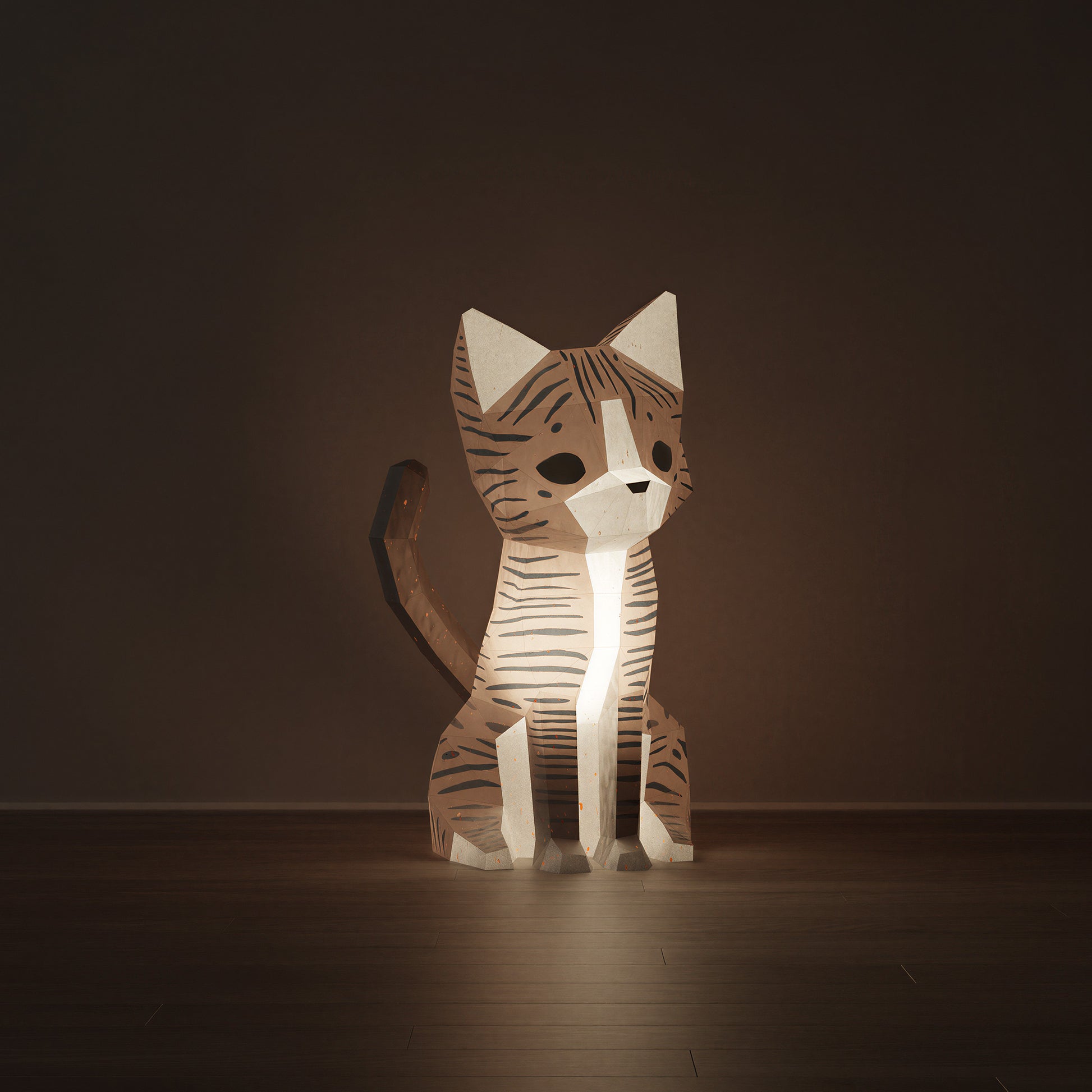 Sculpture en papier Neko le chat allumée en veilleuse, diffusant une lumière douce et chaleureuse. Kit origami 3D aux teintes sable et blanc au design épuré, luminaire artisanal à assembler avec colle. Notre chat regarde de face