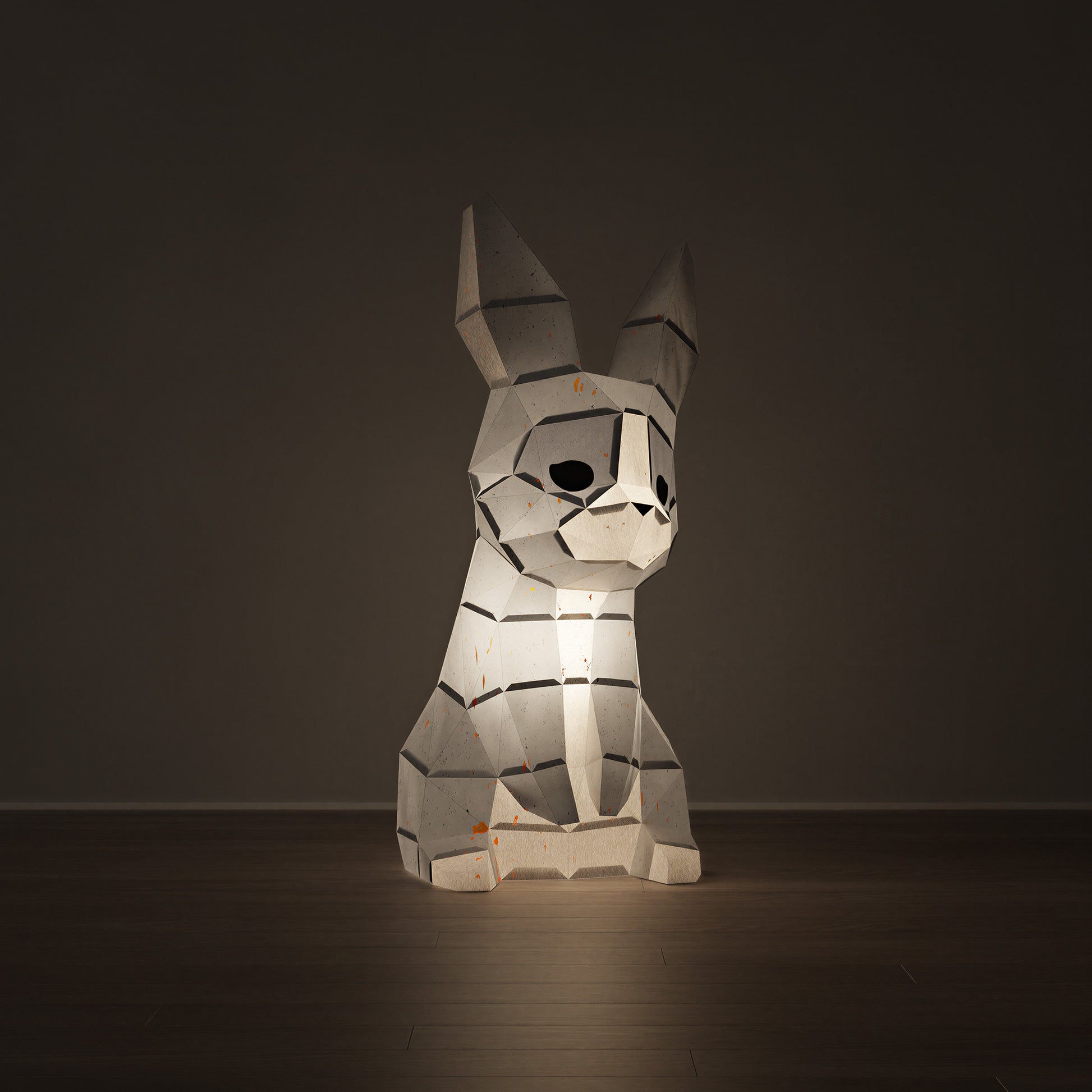 Veilleuse en papier d'un lapin en origami 3D allumée en veilleuse, diffusant une lumière douce et chaleureuse à travers ses facettes. Kit créatif au design épuré à assembler avec colle, décoration lumineuse