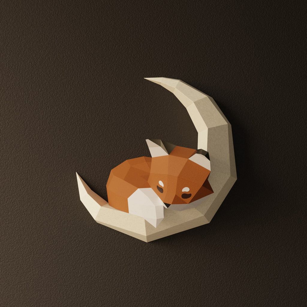 Décoration murale en papier d'un renard roux et blanc endormi, lové au creux d'un croissant de lune géométrique blanc. Kit origami 3D au design épuré