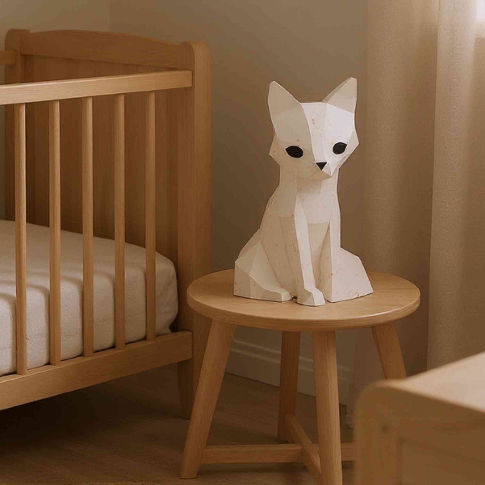 veilleuse bébé et enfant renard en papier style origami 3D - la veilleuse est éteinte, et donc blanche. La veilleuse est sur un tabouret à côté d'un lit de bébé.