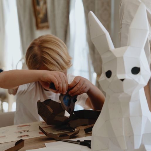 Photo d'enfant en train de construire son origami 3D avec le kit papercraft Moki Moki - en premier plan la veilleuse lapin Moki Moki