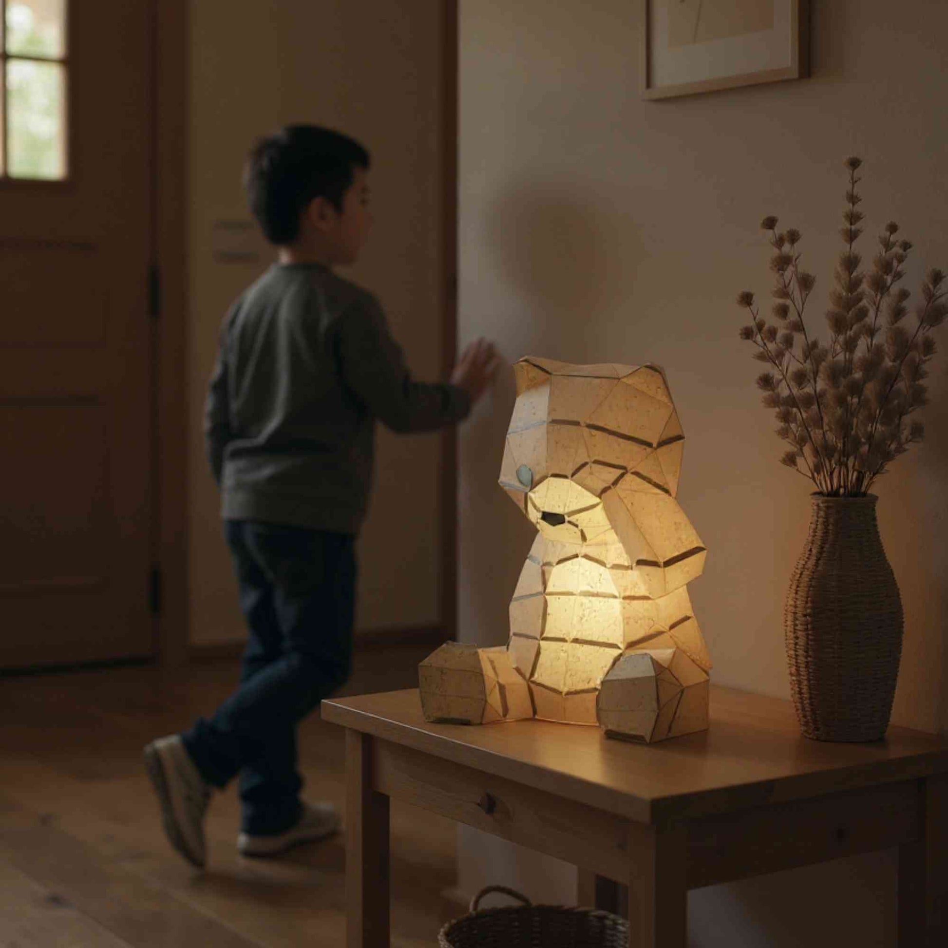 La lampe ourson en papier style origami 3D est sur une table basse en décoration intérieure dans une maison. La veilleuse est allumée ce qui révèle la couleur naturelle de l'ours. Un petit garçon est en train de passer à côté.