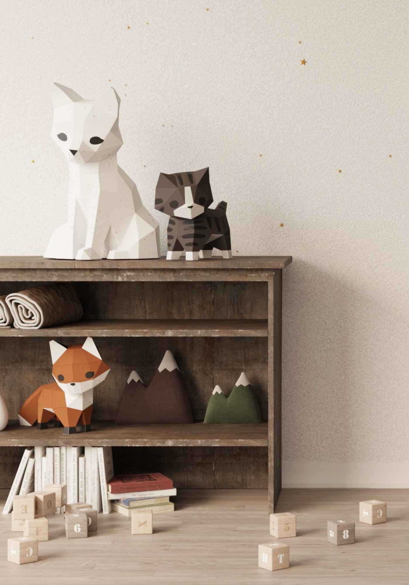 dans une chambre d'enfant, on voit les créations en papier Moki Moki en style origami. Les papercrafts 3D sur la photo sont : la veilleuse renard, le wall art applique murale ourson, le petit chat et le renardeau en papier.