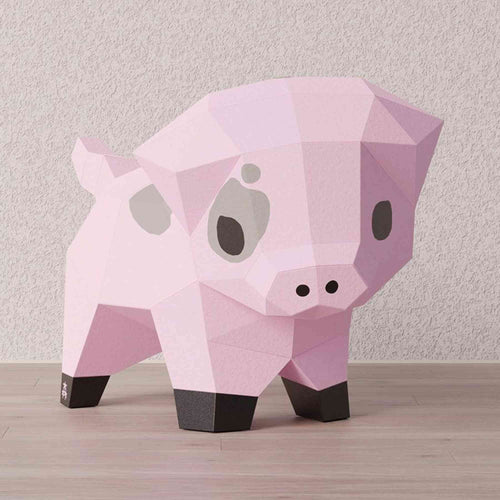Kit papercraft 3D complet d'un petit cochon. L'animal de la ferme est en papier créatif coloré et imprimé de ses couleurs naturelles dans un style d'origami. Le petit cochon est de face.