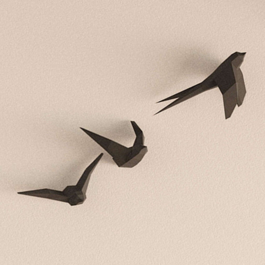 photo en gros plan du wall art des hirondelles. On voit les appliques murales de 3 oiseaux en vol accroché sur un mur.