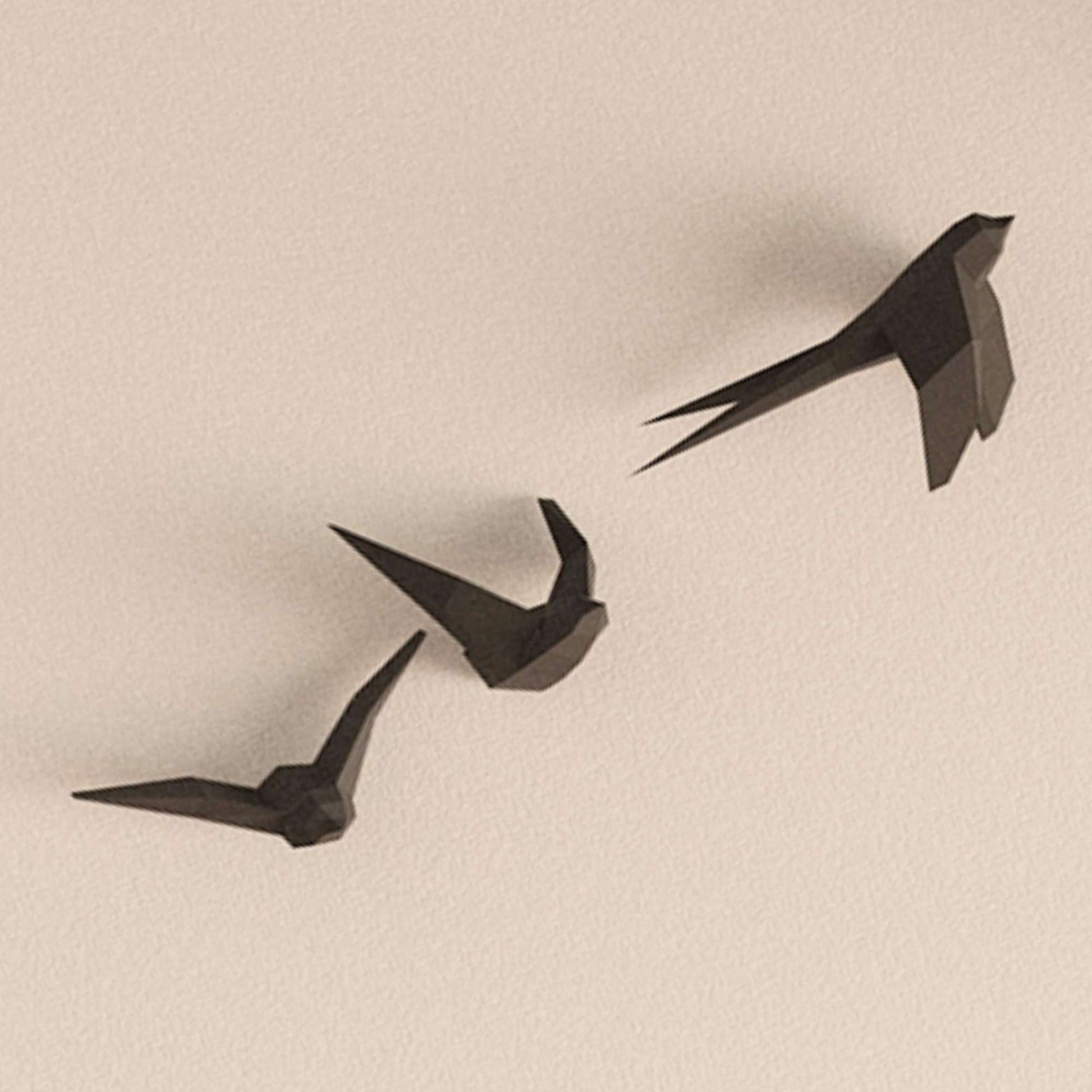 photo en gros plan du wall art des hirondelles. On voit les appliques murales de 3 oiseaux en vol accroché sur un mur.